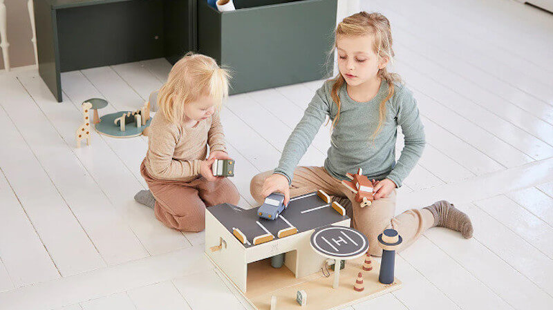 dos niños con juguetes de madera Flexa