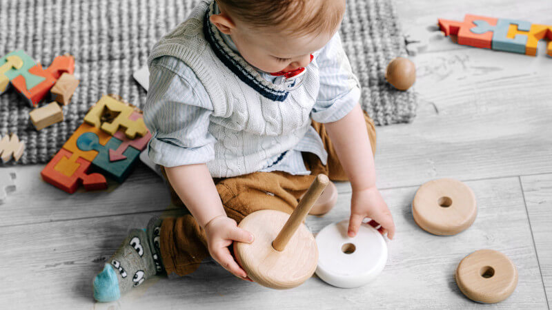 un bebé jugando con juguetes de madera ecológicamente sostenibles 2