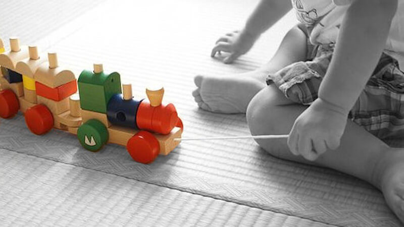 un bebé jugando con un juguete de tracción