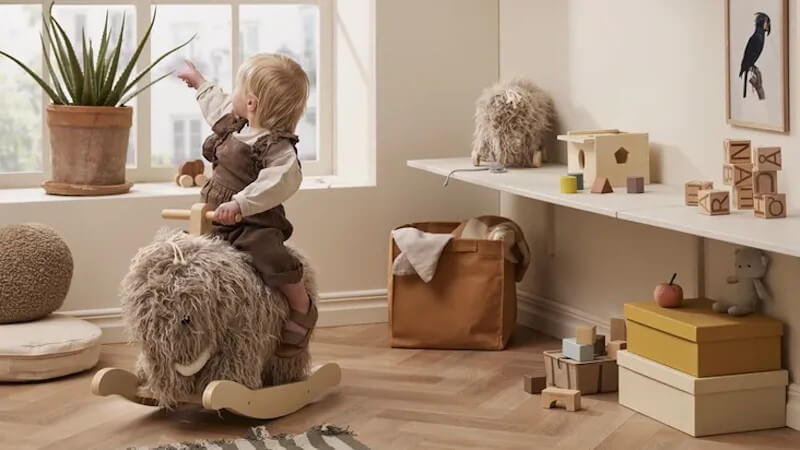 un niño en un caballito balancín de la marca kids concept